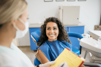 Dental professional consulting with patient in modern clinic, highlighting routine check-up and patient care.
